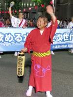 赤い浴衣を着た市長が、右手に提灯を持ち左手を上に掲げている写真