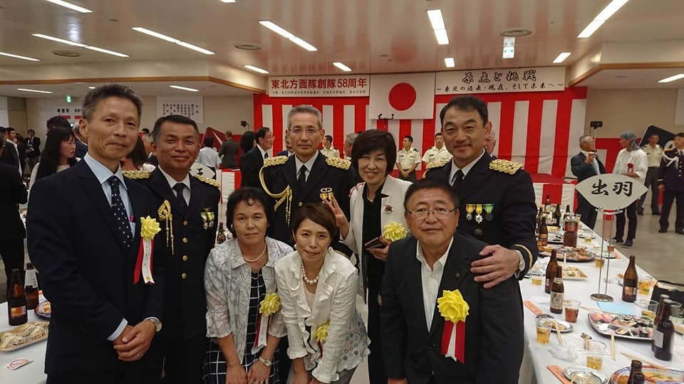 黄色い胸章を着けた市長や関係者の方々と、上尾秀樹陸上自衛隊東北方面総監、滝澤博文第6師団副師団長、清田安志第6師団長の記念写真