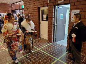 会場を歩いている晴れ着姿の新成人2人に、市長が声をかけている写真