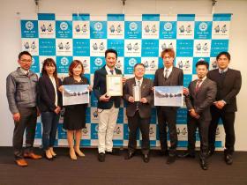 盛岡クロスオーバーズの7人と寄付金の目録を持った市長が並んで撮影した写真