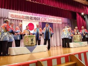 令和6年田老地区新春のつどいの舞台の上に2ケの酒樽が用意され関係者の方が囲んでいる写真