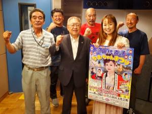 小田代直子さんと、市長含む5名の男性がガッツポーズをしている記念写真