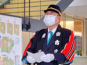 市長が消防団の帽子を被り、法被を着て白の手袋をして式辞を述べている写真