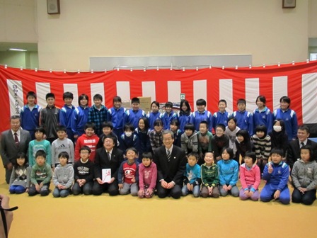 紅白幕の前に市長や関係者と小中学生が集合し3列で並んでいる写真