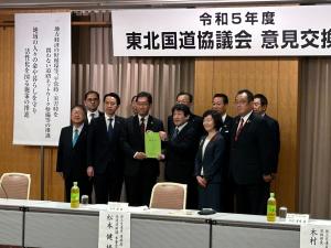 「令和5年度東北国道協議会意見交換会」と書かれた会場で、内田広之いわき市長と国土交通省道路局長の丹羽克彦氏が一緒に要望書を持ち、市長と8名の関係者が2列に並んでいる写真