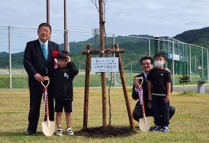 植樹したもみじの両脇に市長と高樋憲市長がそれぞれ子供と並んで撮影した写真