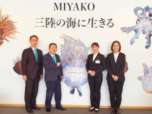 MIYAKO三陸の海に生きると書かれた幕の前で、平沼里穂子さんと女性1名、市長、副市長が並んでいる写真