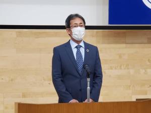 スタンドマイクが置かれた演台を前に話をする様子の佐藤廣昭副市長の写真