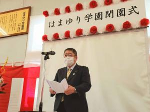 「はまゆり学園閉園式」と書かれた看板が後方の壁に設置された会場で、スタンドマイクの前で式辞用紙を両手に持ち話をしている様子の市長の写真
