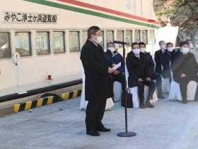 市長がラストランになる浄土ヶ浜遊覧船を背景に出席者の方々が見ている中、式辞を述べている写真