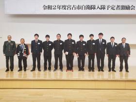 令和2年度宮古市自衛隊入隊予定者激励会と書かれた幕の下で激励会に出席した入隊予定の8人と市長と市職員、自衛隊関係者の方が横に並んで撮影した写真