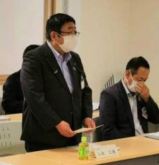 市長が自席で立ち、資料を持って話をしている写真