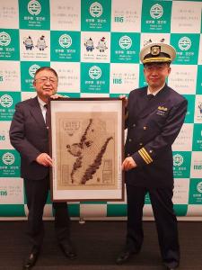 宮古市のバックパネルの前で、額に入った宮古港の海図「陸中國宮古港之圖」のレプリカを宮古海上保安署の戸由恵一署長と市長が持っている写真