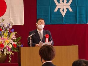 花が飾られた演台で、市長が入校される皆さんに向けて祝辞を述べている写真