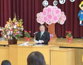 演台の前で手紙を両手で広げ話をする市長の写真