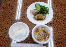 白ご飯、汁物、ピーマンを使用したおかずが入れられた器が並んでいる写真