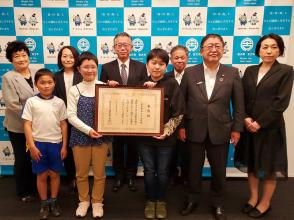 文部科学大臣表彰を受賞した山口小学校6年生の栗原陽吏さん(図書委員会委員長)と田代百花さん(同副委員長)が、文部科学大臣表彰の賞状を持ち、市長と他の関係者の方々が集合して撮影した写真
