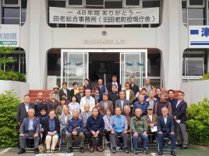 「48年間ありがとう 田老総合事務所<旧田老町役場庁舎>」と書かれた横断幕が建物2階の窓に掲げられ、建物の前で4列になって並ぶ関係者たちの写真