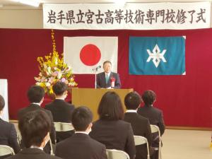 市長が岩手県立宮古高等技術専門校修了式と書かれた横断幕の下の演台で式辞を述べていて、それを座って聞いている修了生の写真