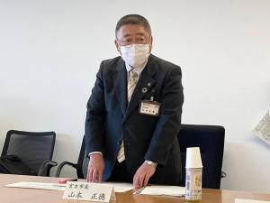 席札が置かれた席から立ち上がった市長が話をしている宮古地区広域市町村連携推進会議の様子の写真