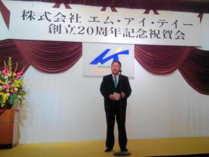 「株式会社エム・アイ・ティー創立20周年記念祝賀会」と書かれた横断幕が掲げられたステージ上で挨拶を行っている市長の写真