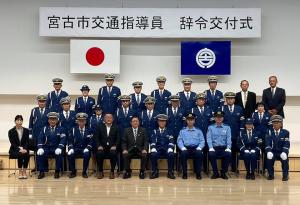 宮古市交通指導員辞令交付式と書かれた横断幕を背景に市長と制服姿の指導員の方々が集合して撮影した写真
