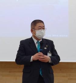 スクリーンの前で市長が話している写真