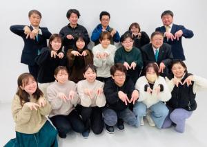 市内企業へのインターン生13名と市長と関係者2名の全員が両手でピースをして手のひらをみせ人差し指をくっつけた同じポーズで記念撮影をしている写真