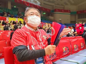 赤いユニフォームを来た市長がメガホンをもって、応援している写真