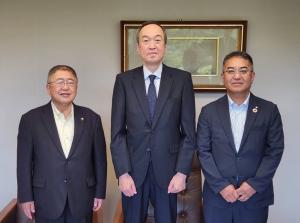 スーツを着た市長や松木健社長ら3名が並んでいる写真