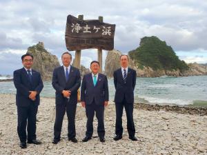 浄土ヶ浜と書かれた木製の看板の前で立って写真に写る市長と3人の男性の写真