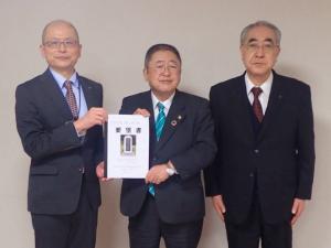市長が要望書を手に持ち、両端に男性二人を挟んで立ち並んでいる写真