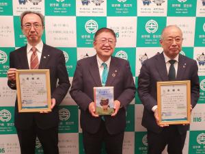 市長が寄贈いただいた絵本、宮古信用金庫の2人は市からの感謝状をそれぞれ持って並んで撮影した写真