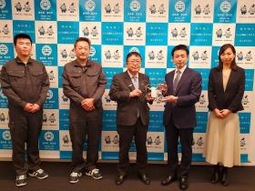 真柴商会株式会社の4人の内、1人の方と市長で寄贈していただいたドローンを持ち、並んで撮影した写真
