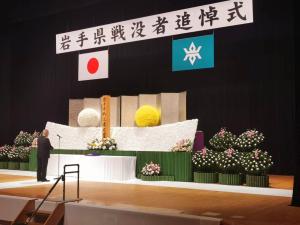 山本市長がステージに上がり、ステージに設置された慰霊碑に向かい追悼の言葉を述べている様子の写真