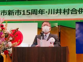 宮古市新市15周年・川井村合併10周年と書かれた横断幕の下、市長が演壇に立ち、式辞を述べている写真