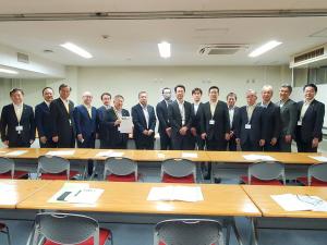 要望書を持つ市長と、関係者の男性15名が横一列に並ぶ記念写真