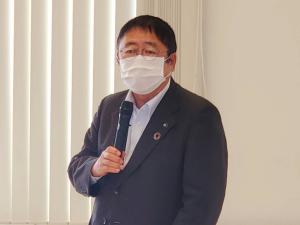 マスクをして右手にマイクを持った市長が話している様子の写真