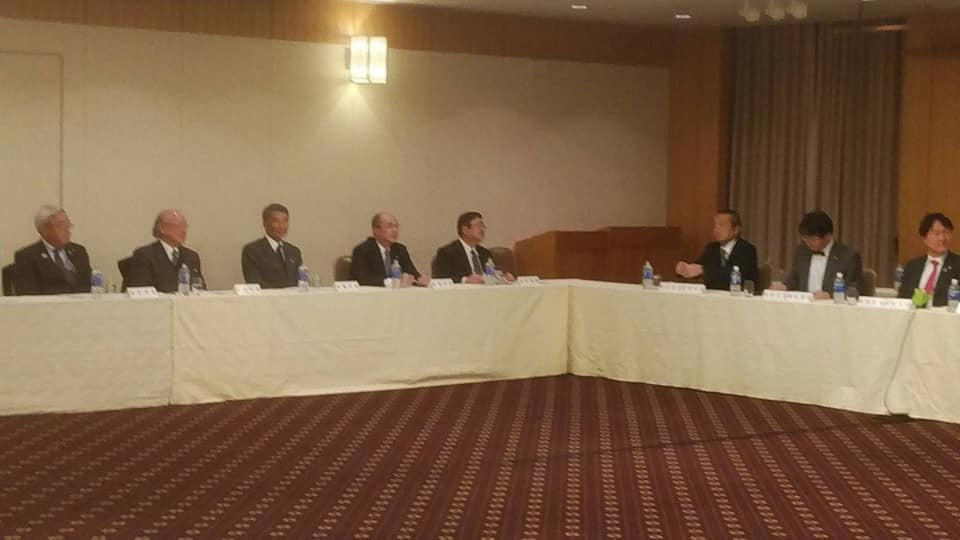 テーブルクロスが掛けられた長机が並んだ席に市長や参加者が座り、右奥に座っている男性の話を熱心に聞いている委員会の様子の写真