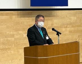 演台に置かれたスタンドマイクの前で演説をしている様子の白いマスクをした市長の写真