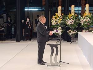 市長が花輪が置かれた祭壇の前で、式辞を述べている写真