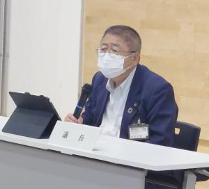 椅子に座って右手にマイクを持ち話している市長の写真