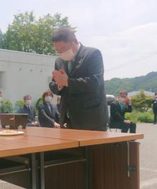 長香炉が置かれたテーブルに向かって目を閉じて頭を少し下げ合掌している様子の市長の写真