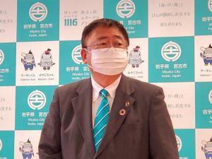 バックパネルの前で記者会見を行っている市長をアップで撮影した写真