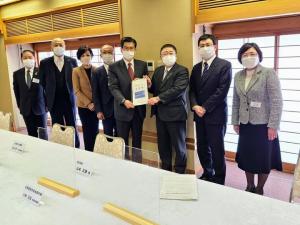要望書を一緒に持つ市長と男性、2人を中心に左側に3名の男性と1名の女性、右側に男性と女性が1人ずつ立って横一列に並んでいる写真