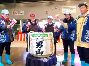 男山と書かれた酒樽を宮古市魚市場の関係者4名と一緒に鏡開きしようとしている市長の写真