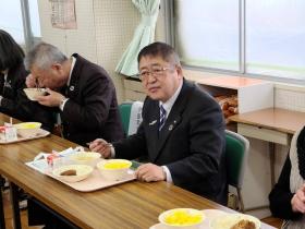 市長が中学校の教室で、配膳盆に置いてあるナミビア給食を食べている写真