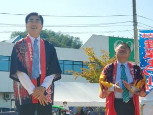 法被を着た男性と市長が視線を前方斜め上に向けている写真