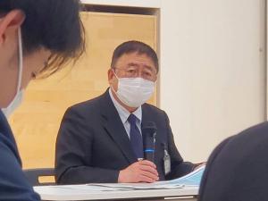 新規採用された職員の研修会場で、右手にマイクを持った市長が話をしている様子の写真