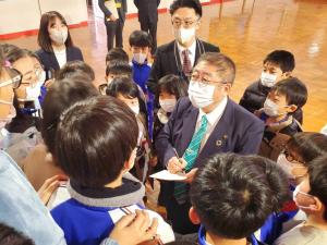 児童たちからとり囲まれ、市長がメモを取っている写真